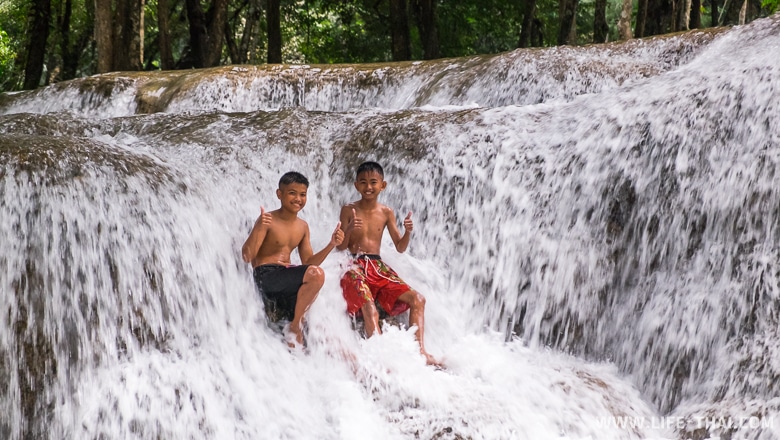 Дети играются на водопаде, Канчанабури, Таиланд