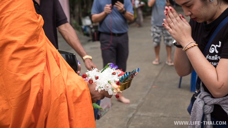 Люди отдают подаяние монаху и молятся, Таиланд