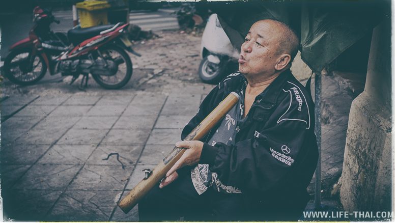 Вьетнамский мужчина курит Thuoc Lao
