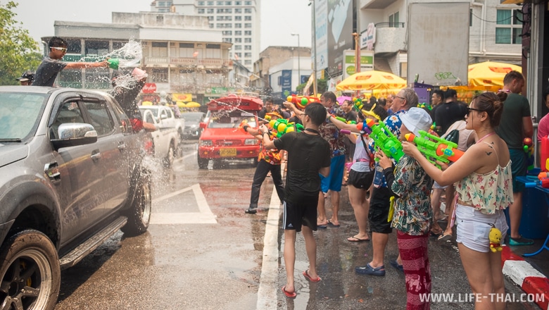 Люди на улице обливаются водой во время празднования тайского нового года в Чиангмае