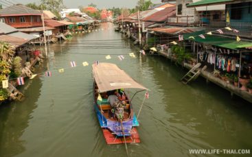 Лодка плывёт по каналу в Ампхаве Плавучий рынок Ампхава около Бангкока