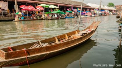 Пустая деревянная лодка на фоне рынка Фото: плавучий рынок Ампхава в Бангкоке