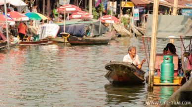 Человек в деревянной лодке Рынок на реке Меклонг в Ампхаве